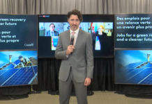 Prime Minister Trudeau and Carleton’s Efficiency Canada announce Greener Homes initiative Canadian Prime Minister Justin Trudeau stands in front of posters mid-announcment, holding a microphone.