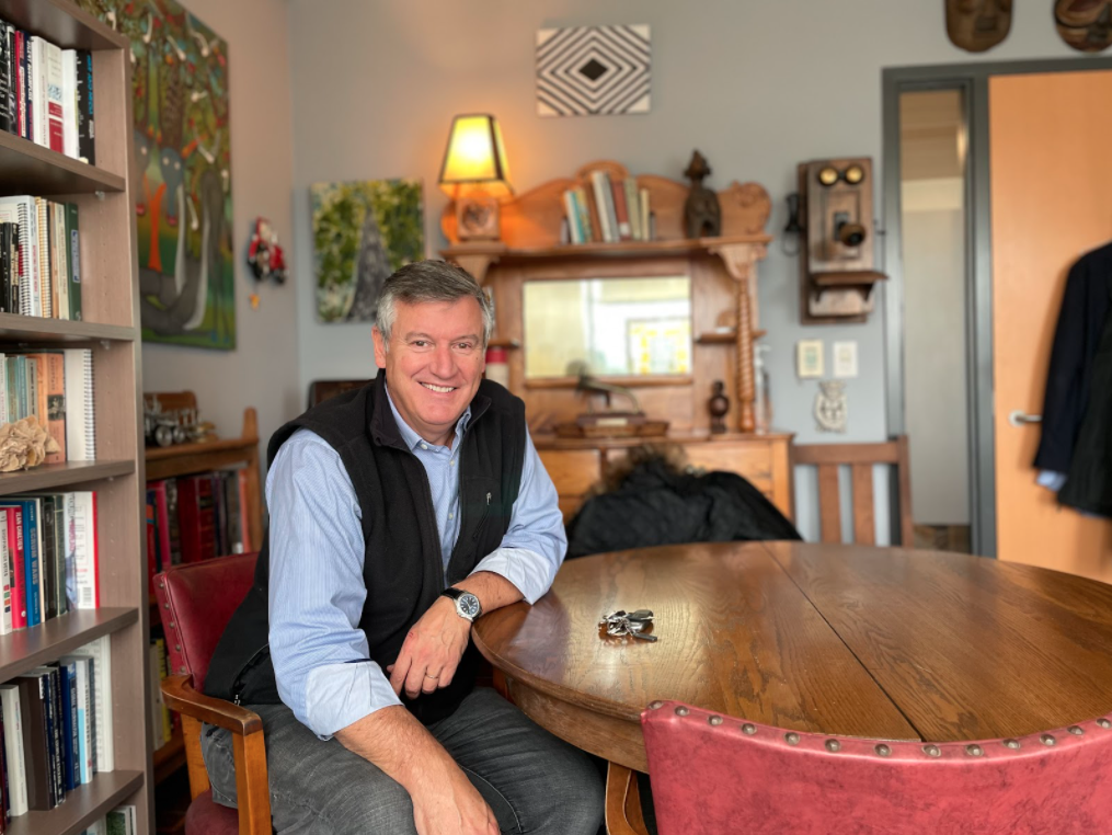Photo of Allan Thompson sitting at a round wooden table in his office. 