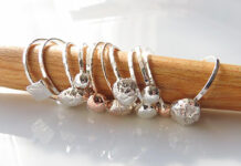 Profile: Geneviève Folliet-Multone’s Crazy Little Desire Several rings are pictured on display along a wooden post at a jewelry store.