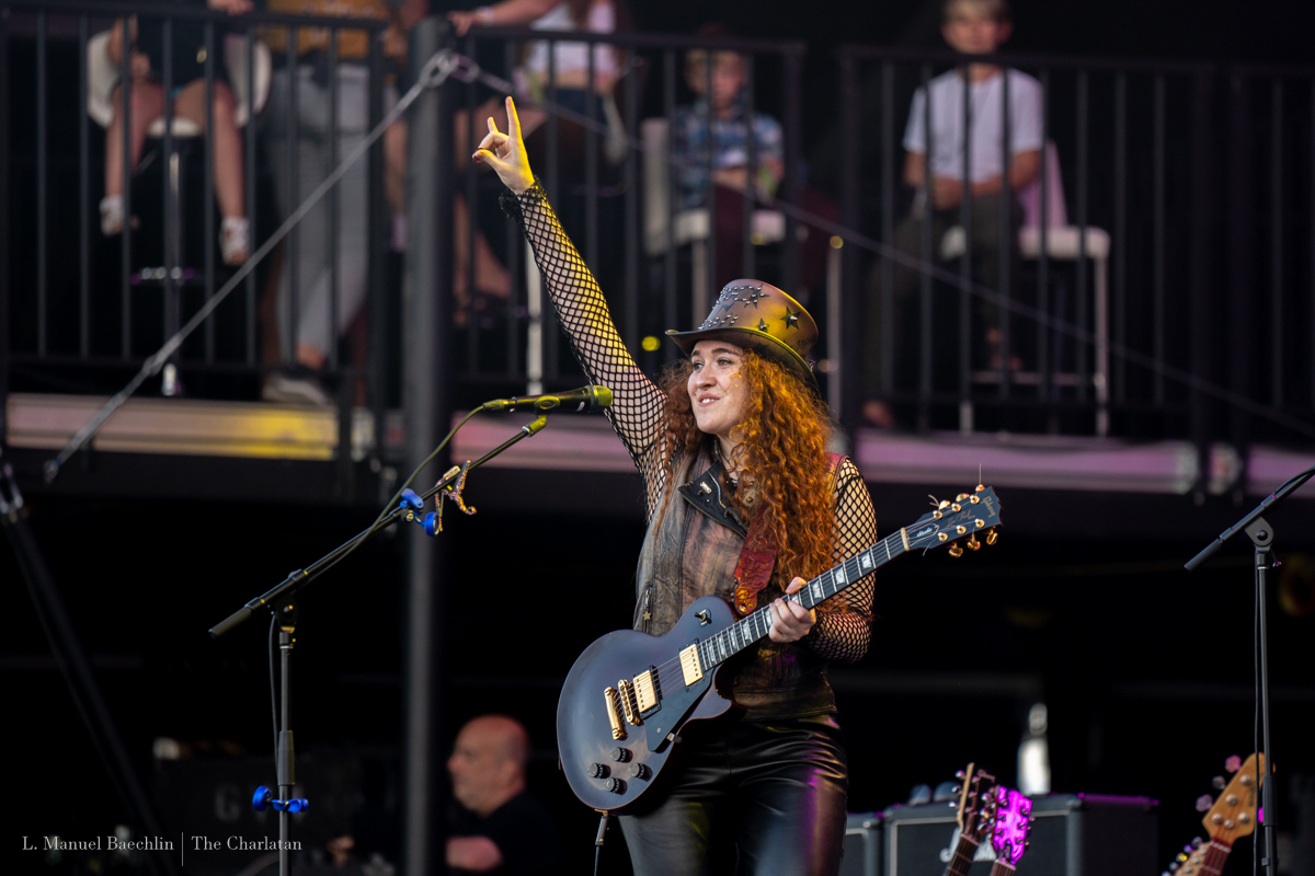 Sophia Radisch performs at Bluesfest. She smiles and makes a peace sign into the air.