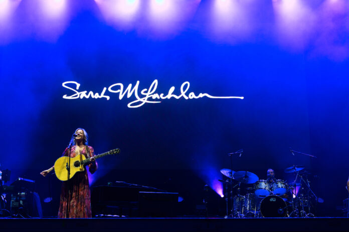 Sarah McLachlan performs on the stage at Bluesfest. Her name is projected on the screen behind her.