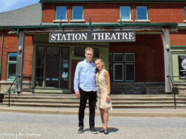 Ted and Marion Outerbridge pose for a photo outside the Station Theatre, an old train station converted into a theatre.