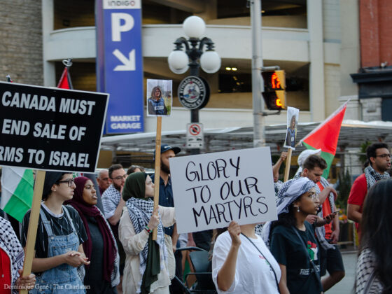 Pro-Palestine protesters march down Laurier Avenue in Ottawa, holding signs that read “Glory to our martyrs” and “Canada must end arm sales to Israel,” as well as photos of journalist Shireen Abu-Akleh, who was killed by Israeli forces on May 11.