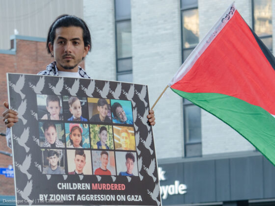 A protester seen holding a sign showing photos of Palestinian children killed in the recent attacks in Gaza at the pro-Palestine protest in Ottawa on Wednesday, Aug 10.