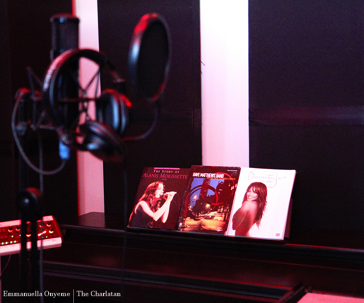 Musical books are displayed on a piano in Cave 3.0 Recording Studios. Recording headphones are in the forefront of the shot.