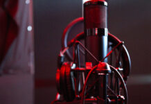 Cave 3.0 Recording Studios: Home to Ottawa’s hip hop, rap and R&B artists A microphone with headphones draped around it at Cave Recording Studios behind a dark background.
