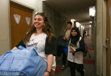 Carleton students move in for a full return to campus Three people walking with boxes