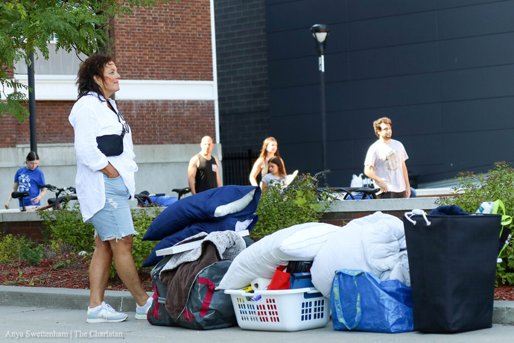  A person stands with bags and boxes on the floor