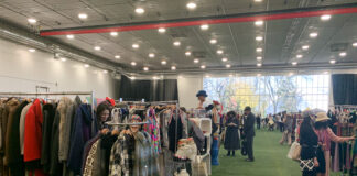 Tables and booths line the inside of Carleton University's Fieldhouse, selling items such as vintage clothes and antique jewelry.