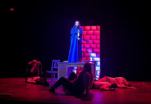 Review: Sock ‘n’ Buskin’s ‘Dracula’ delivers a performance filled with love, horror and sacrifice Lindsey Keene as Dracula stand up on a platform on stage with bodies laying on the stage around her.