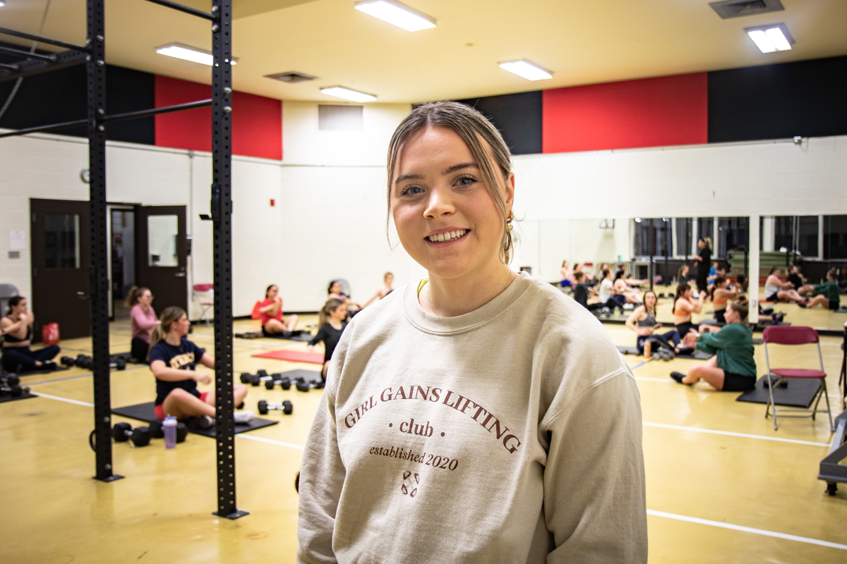 Girl Gains president Kaitlyn Altwasser smiles at the camera in the centre of a fitness class