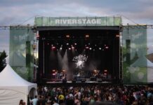 Here’s what you need to know ahead of Bluesfest 2025 A large stage reading "River Stage" overhead is lit up with a band, in front of a large crowd.
