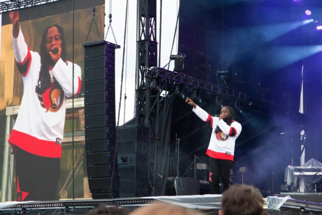 Ottawa-based City Fidelia rapping to the crowd in a Senators jersey on July 6, 2024. [Photo by Darren Tran/The Charlatan]