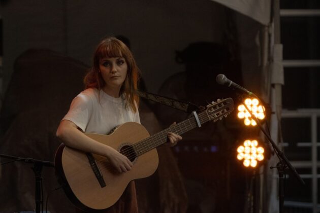 Oddeline strums her guitar on the River Stage on July 12, 2024. [Photo by Nisse Anonby/The Charlatan]