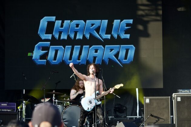 Charlie Edward sings and strums his guitar shirtless on stage on July 13, 2024. [Photo by Alexa MacKie/The Charlatan]