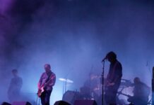 Review of CityFolk Day Three: A night of melodic intimacy across genres Blue background smoke reveals 3 man playing guitar on stage.