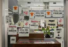 Carleton’s Book Arts Society brings back the printing press On a glass window, around 20 posters speaking to Indigenous issues for National Day of Truth and Reconciliation are displayed.