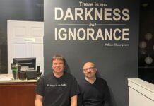 Ottawa’s first dine-in-the-dark restaurant aims to ‘heighten the senses’ Underneath a sign that reads "There is no darkness but ignorance," two men sit wearing black shirts. The one on the left is a blind server, while the one on the right is the owner of the restuarant.