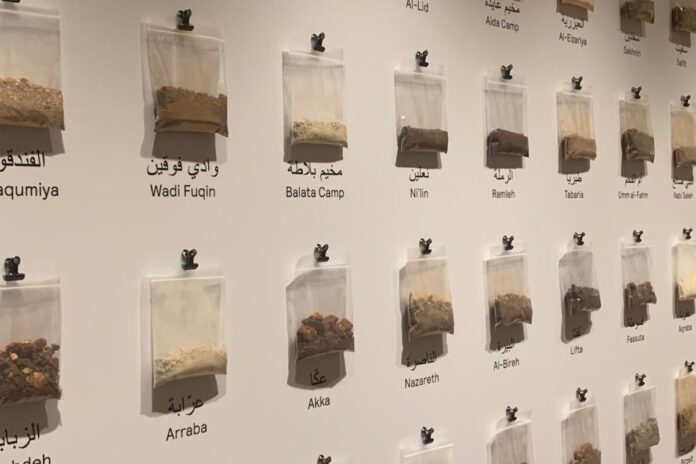 Bags of dirt with place names under it attached to the wall.