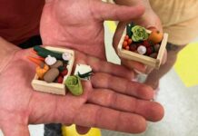 Miniature art is getting big in Ottawa Close up of two hand palms with small clay vegetables in the middle.