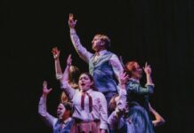 Review: ‘Spring Awakening’ beckons generational change Six people sing next to each other with their right hand in the air.