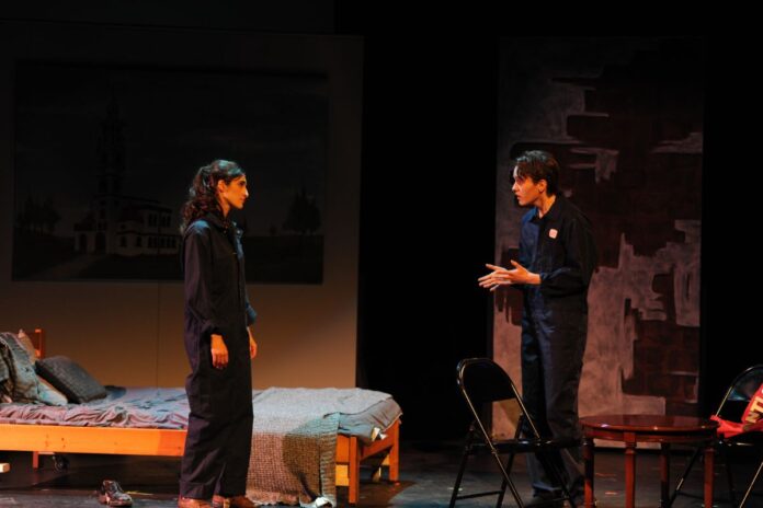 On stage, the two main characters in 1984, Julia and Winston, have a heated discussion.