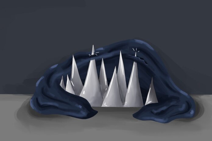 A navy blanket lays atop spikes. The spikes stick out.