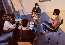 New mentorship program aims to expand Ottawa’s arts scene In a room, four masked people sit around a table and discuss ideas. There are notebooks out and pencils and a whiteboard.