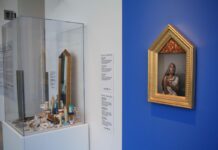 OAG’s ‘Saints and Madonnas’ explores divinity and holiness in everyday life On a blue painted wall, there is a photo of a woman dressed to look like madonna. In the glass container next to it, its full of little trinkets like pill bottles, gold jewellery, and pearls.