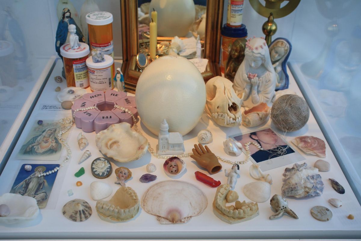 In a glass case, there are objects Johnston has collected throughout the years, including seashells, teeth, Madonnas, prescription pill bottles, ceramic pieces and religious artifacts. 