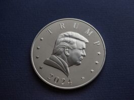 A 2024 President Donald J. Trump silver coin sits on a simple textured background.