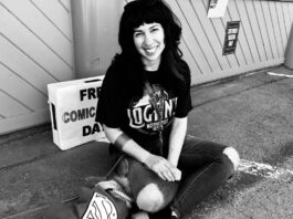 A woman wearing ripped jeans and a black tshirt sits outside an old comic shop, Happy Harbor Comics, in Edmonton on Free Comic Book Day in 2018.