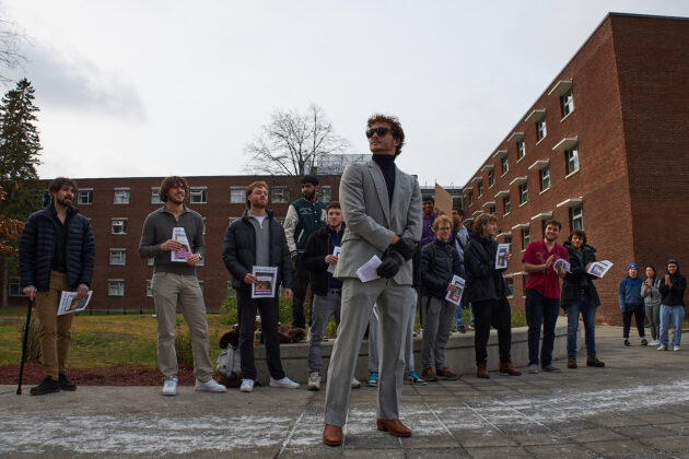 A young man accepting applause from a group of men