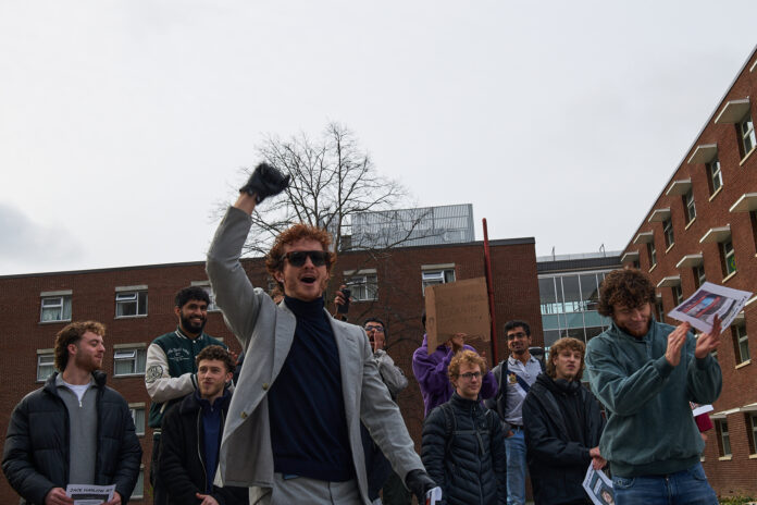 Young man raises his fist after winning a lookalike contest.