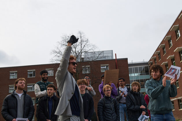 A young man raises his fist in triumph after winning a competition