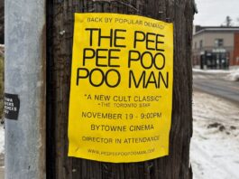 A yellow poster saying in big bight letters "The Pee Pee Poo Poo Man" on a brown post.