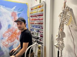 Adrian Gor sits in his studio, where he makes oil painting prints and pastel drawings, on Jan. 18, 2025. His latest exhibit ‘Retold Prototypes Without A Story’ challenges ideals of masculinity through art. [Photo by Thuy Anh Nguyen/The Charlatan]