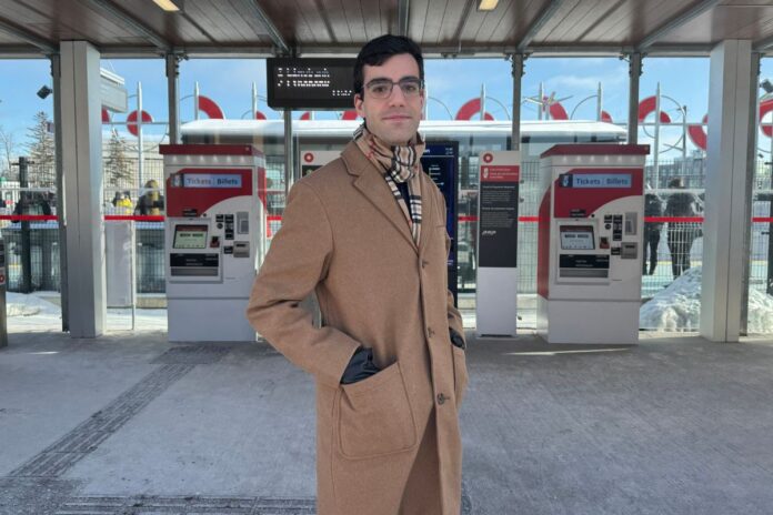 Documentary filmmaker Gio Petti stands in front of OC Transpo’s Line 2 Carleton University train stop on Jan. 9, 2025.