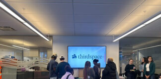 Students gathered around a sign reading Third Space
