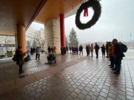 A group of people standing outside City Hall.