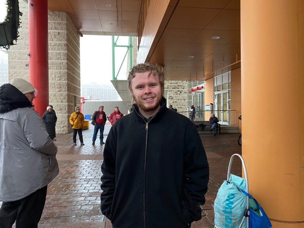 A man with blond hair and a black jacket.