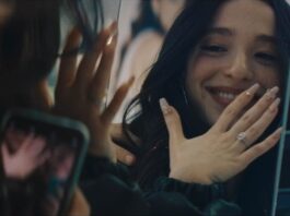 Woman shows off her wedding ring in a mirror.