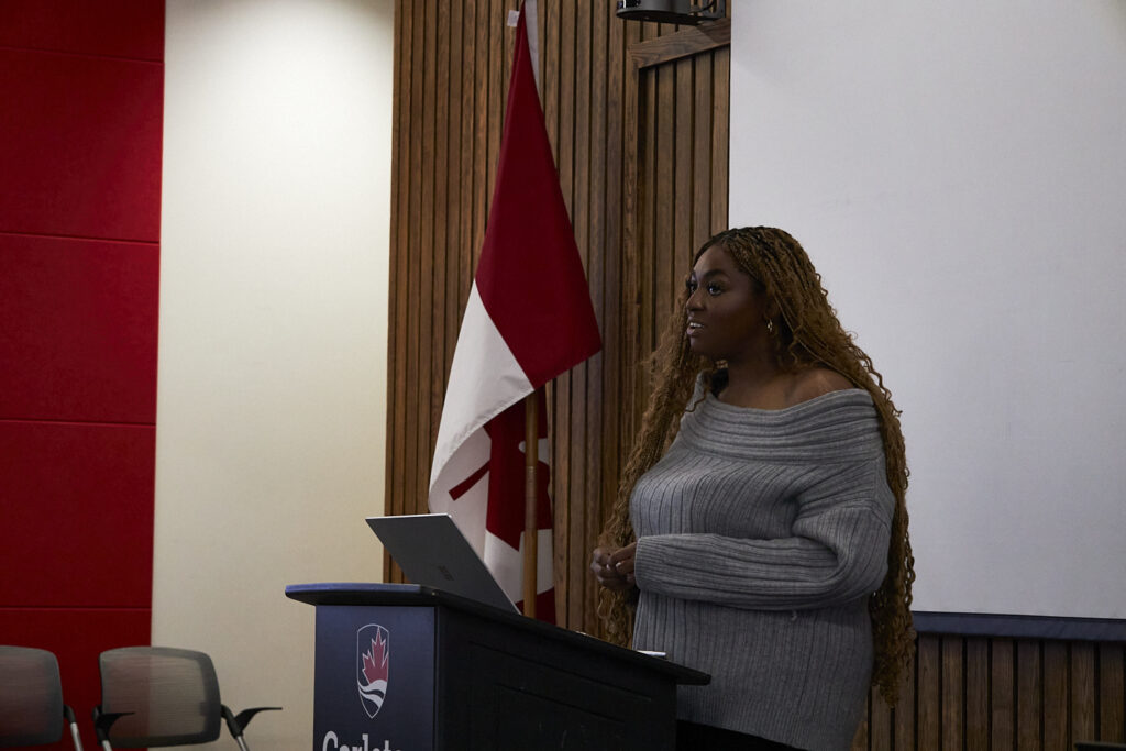 A woman stands at a podium, giving a speech. 