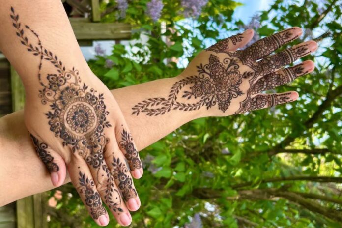 Hands with henna art on it.