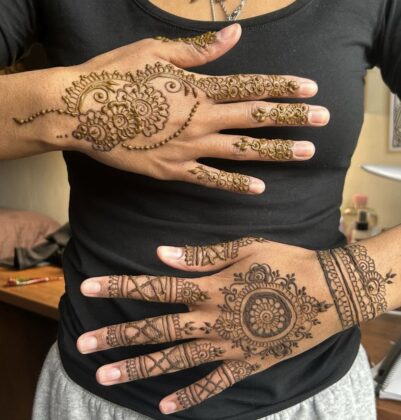 Hands with henna art on it.