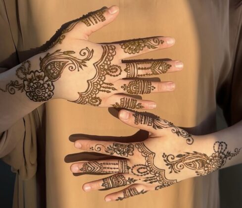 Hands with henna art on it.