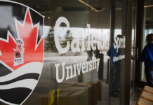 Carleton University logo pasted on the glass wall of a campus building.