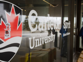 Carleton University logo pasted on the glass wall of a campus building.