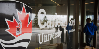 Here’s what Carleton students need to know about tuition increases and university funding changes Carleton University logo pasted on the glass wall of a campus building.