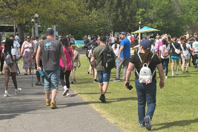 A crowd of people in a park walk.